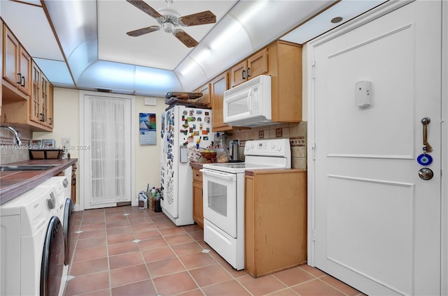 kitchen with backsplash, white appliances, sink, light tile patterned floors, and washing machine and dryer