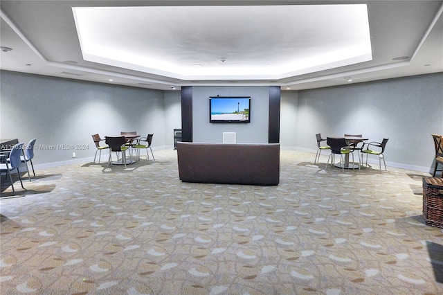 living room featuring a raised ceiling and light colored carpet