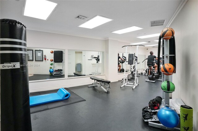 workout area featuring crown molding