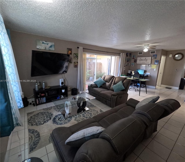 living room featuring ceiling fan, light tile patterned floors, and a textured ceiling