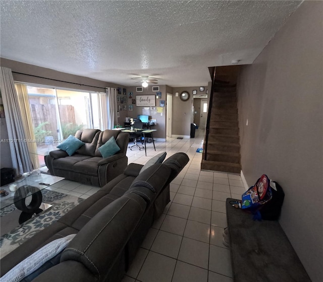 living room featuring ceiling fan, light tile patterned flooring, and a textured ceiling