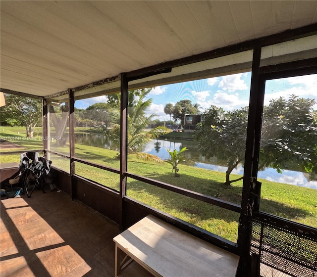 unfurnished sunroom with a water view and wood ceiling