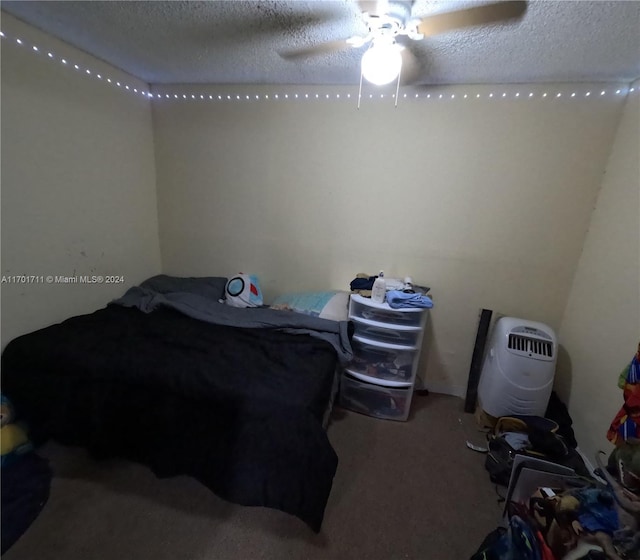 bedroom featuring carpet flooring, ceiling fan, and a textured ceiling