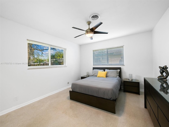 bedroom with ceiling fan and multiple windows