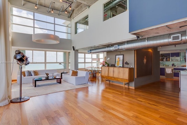 living room with hardwood / wood-style flooring and a towering ceiling