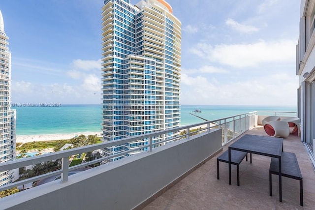 balcony featuring a water view and a beach view