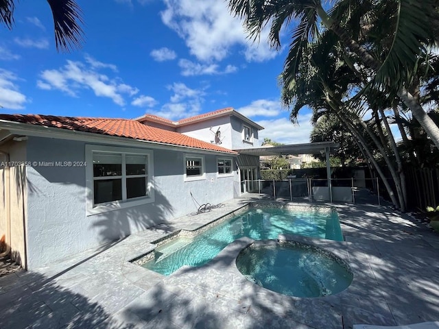 exterior space with a patio area and a pool with hot tub