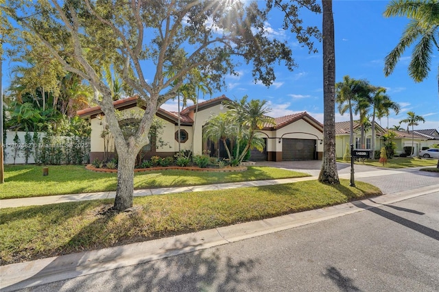 mediterranean / spanish home with a tile roof, an attached garage, driveway, and stucco siding