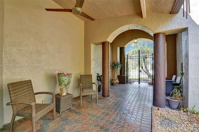 entrance to property with a patio area, stucco siding, and a ceiling fan