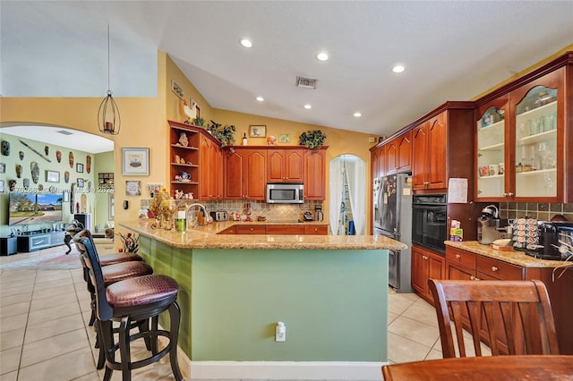 kitchen featuring lofted ceiling, tasteful backsplash, decorative light fixtures, kitchen peninsula, and stainless steel appliances