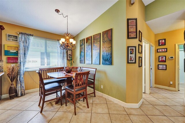 dining area featuring light tile patterned floors, lofted ceiling, and a notable chandelier