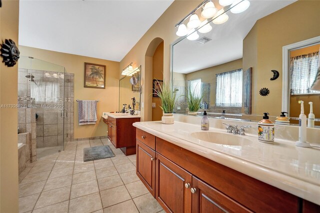 bedroom featuring light wood-type flooring, vaulted ceiling, ensuite bath, and ceiling fan