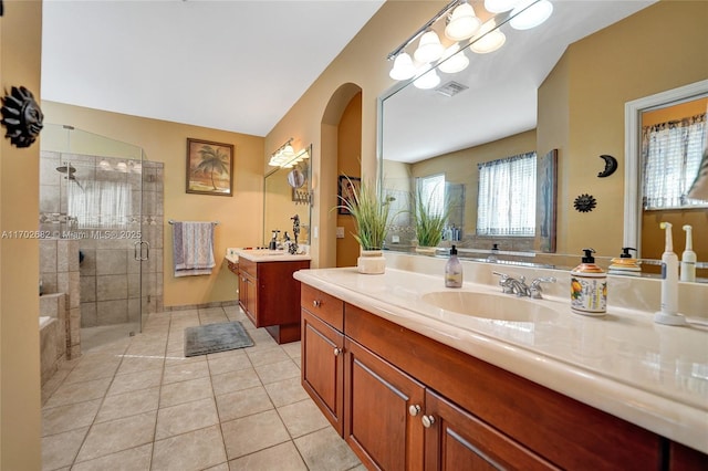 full bathroom featuring tile patterned flooring, visible vents, a shower stall, two vanities, and a sink