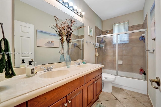 full bath with tile patterned floors, combined bath / shower with glass door, double vanity, and a sink