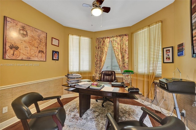 office area with baseboards, a ceiling fan, and wood finished floors