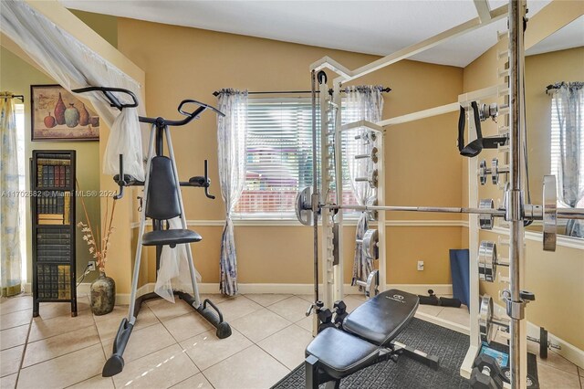 workout area with light tile patterned floors and lofted ceiling