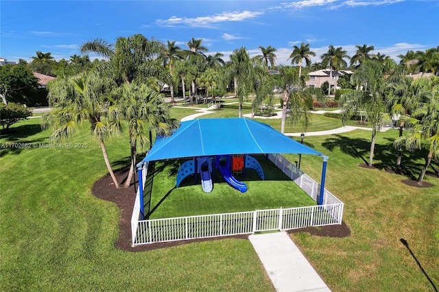 view of home's community with fence, playground community, and a lawn