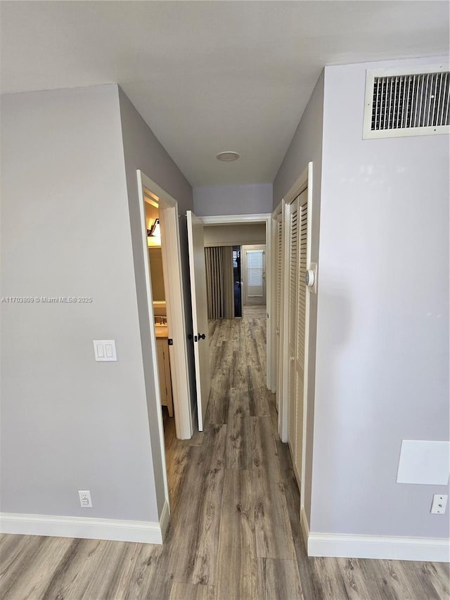 hallway with hardwood / wood-style floors