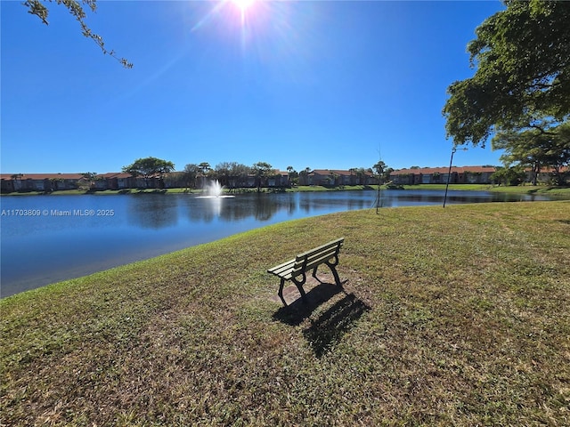 exterior space featuring a lawn and a water view