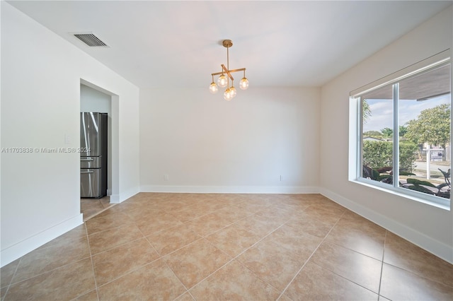 unfurnished room featuring light tile patterned floors and a notable chandelier