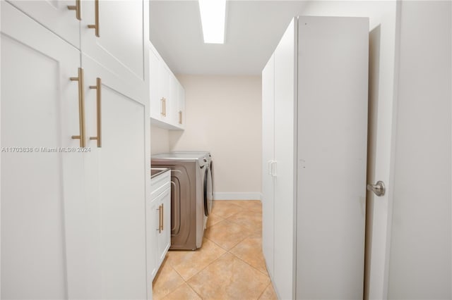 washroom featuring light tile patterned floors, cabinets, and independent washer and dryer