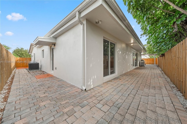 view of side of home with a patio area and central AC