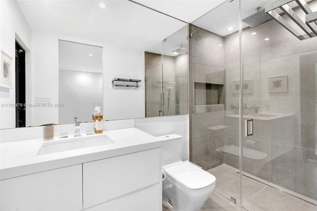 bathroom with tile patterned flooring, vanity, toilet, and a shower with shower door