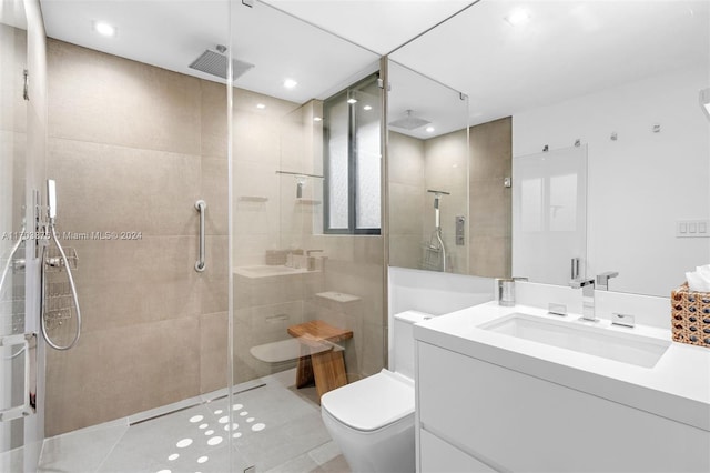 bathroom featuring tile patterned flooring, vanity, toilet, and walk in shower