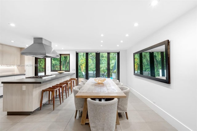 dining area with plenty of natural light, light tile patterned floors, and french doors