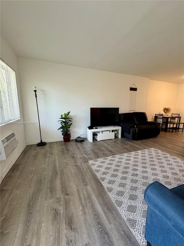 living room with wood-type flooring and an AC wall unit