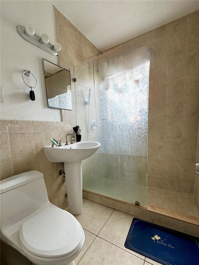 bathroom with tile patterned floors, tiled shower, toilet, and tile walls