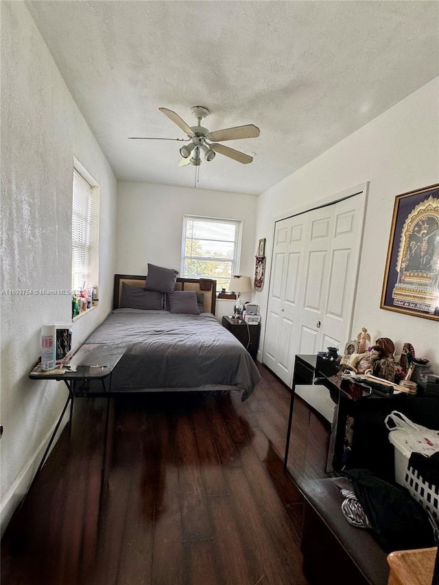 bedroom featuring a textured ceiling, ceiling fan, a closet, and dark hardwood / wood-style floors