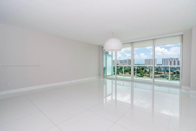 spare room featuring expansive windows and light tile patterned floors