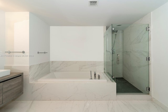 bathroom with vanity and shower with separate bathtub