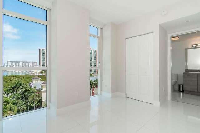 interior space featuring light tile patterned floors, a wealth of natural light, and sink