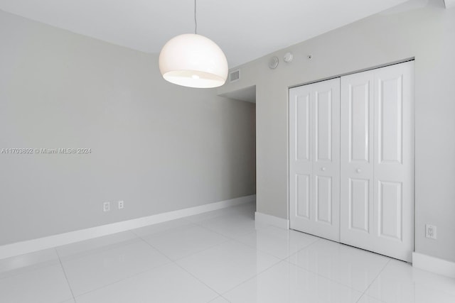 unfurnished bedroom with light tile patterned floors and a closet