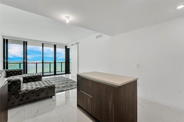 interior space featuring a water view and floor to ceiling windows