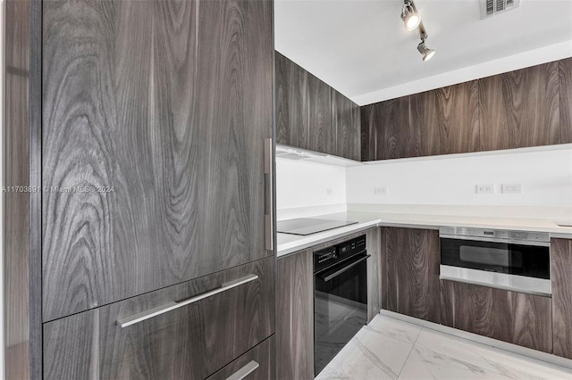 kitchen with dark brown cabinets, black appliances, and track lighting