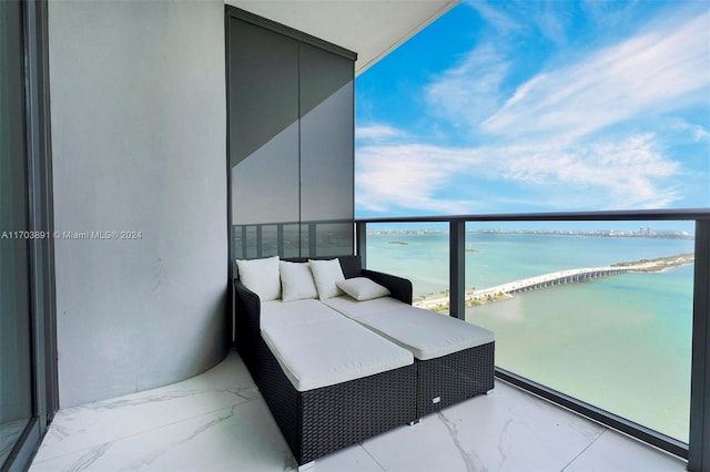 balcony with a water view and a view of the beach