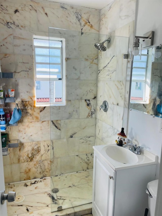 bathroom featuring vanity, toilet, and a tile shower