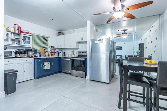 kitchen with white cabinetry, blue cabinets, and appliances with stainless steel finishes