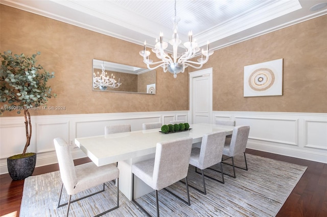 dining room with hardwood / wood-style floors, a tray ceiling, an inviting chandelier, and ornamental molding