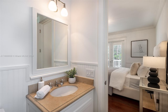 bathroom with wood-type flooring, vanity, and ornamental molding