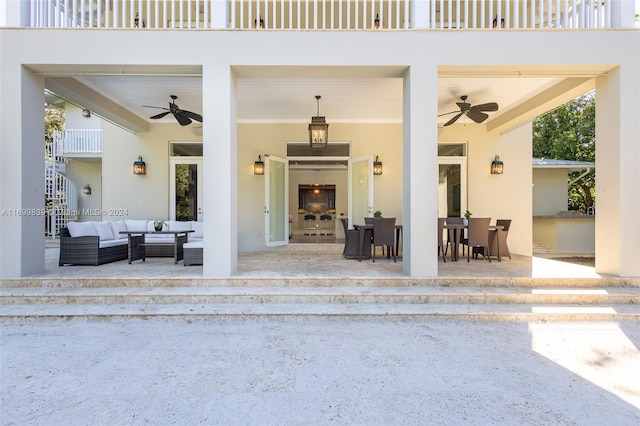 doorway to property with an outdoor living space with a fireplace, a balcony, and a patio area