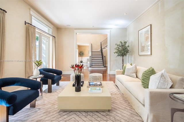 living room with light wood-type flooring and ornamental molding