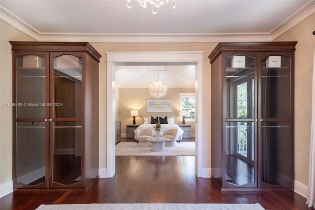 corridor with a notable chandelier, dark hardwood / wood-style floors, and ornamental molding