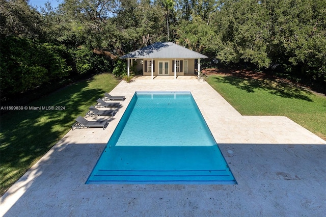 view of swimming pool featuring a patio area, a yard, and an outdoor structure