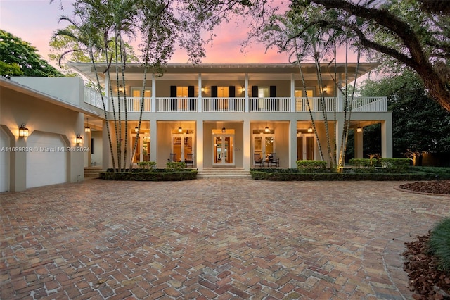 exterior space with a garage, a balcony, and french doors