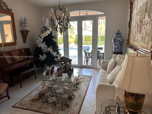 tiled living room with a notable chandelier