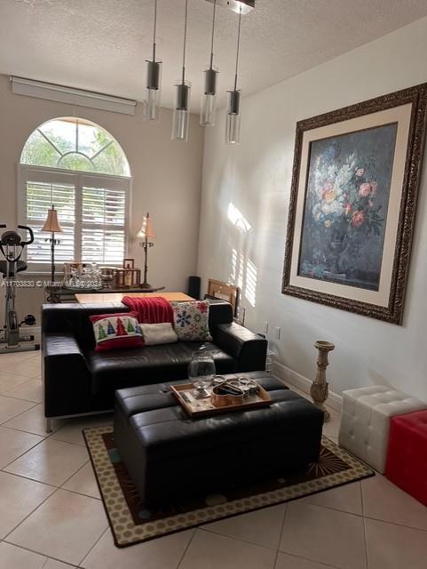 tiled living room featuring a textured ceiling